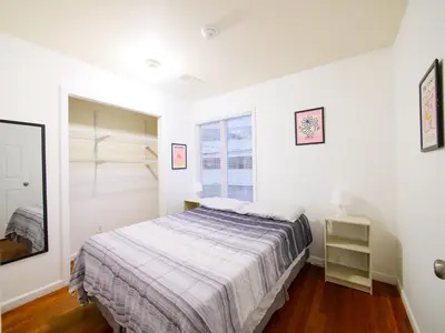 a white bedroom with a bed and a window at Spacious Apt near NYC 7BR Family-Friendly & Modern Amenities in Jersey City