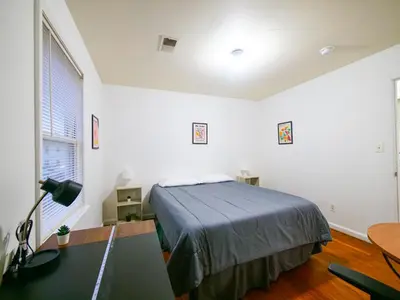 a bedroom with a bed and a desk with a lamp at Spacious Apt near NYC 7BR Family-Friendly & Modern Amenities in Jersey City
