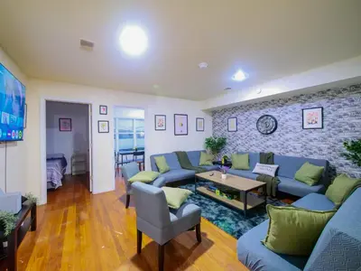a living room with blue couches and a brick wall at Spacious Apt near NYC 7BR Family-Friendly & Modern Amenities in Jersey City