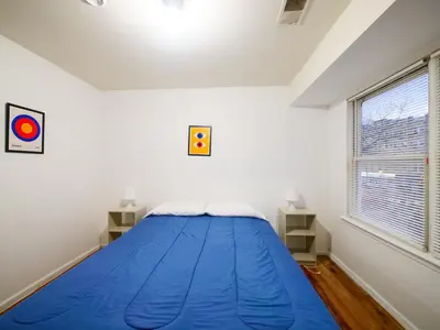 a bedroom with a blue bed in a white room at Spacious Apt near NYC 7BR Family-Friendly & Modern Amenities in Jersey City