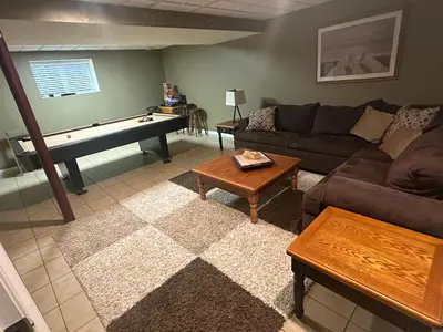 a living room with a couch and a pool table at Wallenpaupack Lake house in Greentown