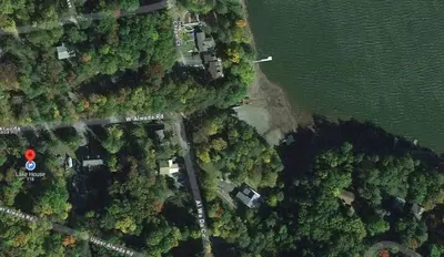an overhead view of a forest with a house and water at Wallenpaupack Lake house in Greentown