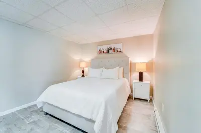 a white bedroom with a white bed and two lamps at Mtn-View Studio 18 Mi to Penn State! in Spring Mills