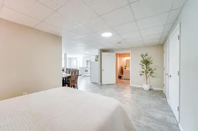 a bedroom with a white bed and a kitchen at Mtn-View Studio 18 Mi to Penn State! in Spring Mills