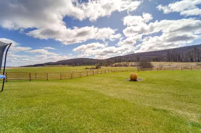 a field of green grass with a fence in the background at Mtn-View Studio 18 Mi to Penn State! in Spring Mills
