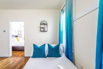 a bedroom with blue curtains and a bed with blue pillows at Family Apt: 2BR FREE Parking Airprt City Links in Newark
