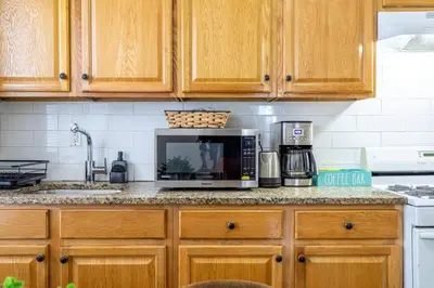 a kitchen with wooden cabinets and a microwave at Family Apt: 2BR FREE Parking Airprt City Links in Newark