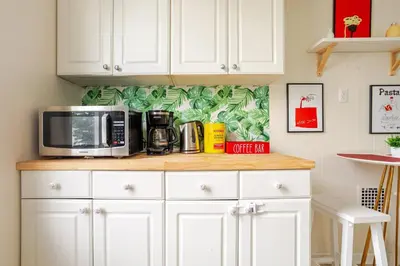 a kitchen with white cabinets and a microwave on a counter at 6-Guest Jersey City Haven: Location-Comfort-Vibes in Jersey City