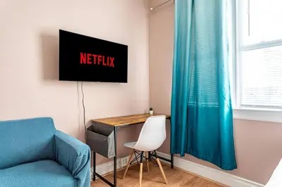 a room with a desk and a chair and a tv at City Outside Serenity Inside: 2B1B NYC - 40 Min in Jersey City