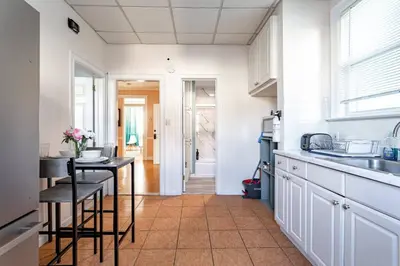 a kitchen with white cabinets and a table at City Outside Serenity Inside: 2B1B NYC - 40 Min in Jersey City