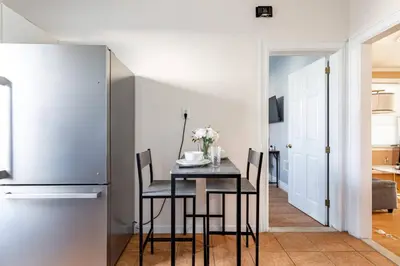a kitchen with a table with chairs and a refrigerator at City Outside Serenity Inside: 2B1B NYC - 40 Min in Jersey City