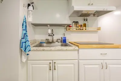 a kitchen with white cabinets and a sink at Big City Life: 1BR Apt wNetflix Easy NYC Access in Jersey City