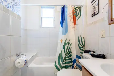 a bathroom with a toilet and a tub and a sink at Family Urban: 2BR FREE Pkng Airport NYC Ease in Newark
