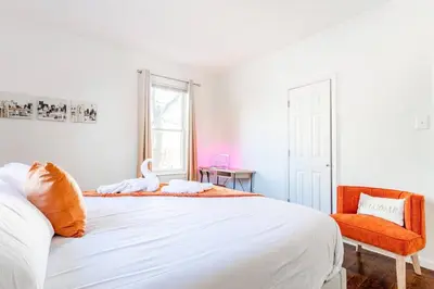 a bedroom with a large white bed and a chair at Family Urban: 2BR FREE Pkng Airport NYC Ease in Newark