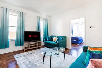 a living room with a couch and a tv at Family Urban: 2BR FREE Pkng Airport NYC Ease in Newark