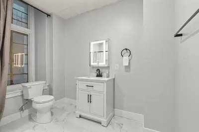a white bathroom with a toilet and a sink at Apartmint at The Metropolitan - Philadelphia in Philadelphia