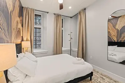 a bedroom with a white bed and a mirror at Apartmint at The Metropolitan - Philadelphia in Philadelphia