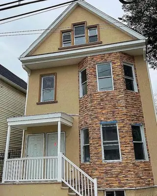a large brick house with a white porch at Newly renovated furnished home in Newark