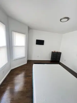 an empty living room with white walls and windows at Newly renovated furnished home in Newark