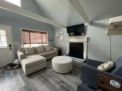 a living room with a couch and a fireplace at Fully updated home with hot tub in amenity filled community in Lackawaxen
