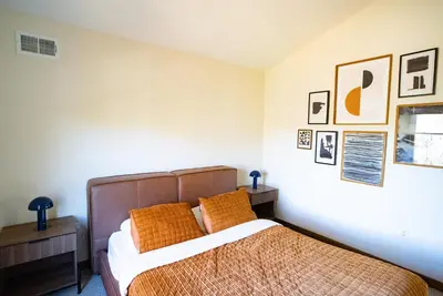 a bedroom with a bed and some pictures on the wall at Luxury Chalet with hot tub in scenic Poconos in Albrightsville