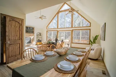 a dining room with a table and a large window at Luxury Chalet with hot tub in scenic Poconos in Albrightsville