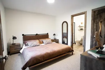a bedroom with a large bed and a mirror at Luxury Chalet with hot tub in scenic Poconos in Albrightsville