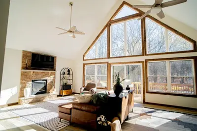 a large living room with a large window at Luxury Chalet with hot tub in scenic Poconos in Albrightsville