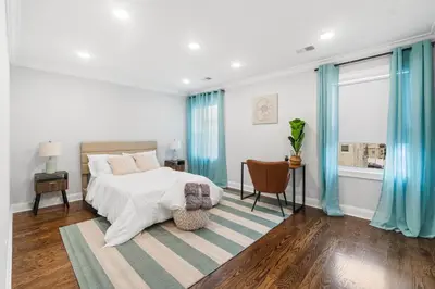 a bedroom with a bed and blue curtains at Orange's Oasis in East Orange