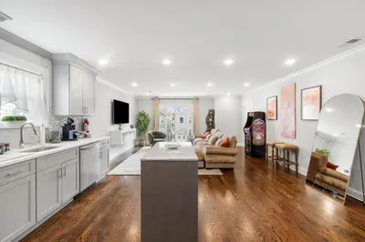 a kitchen and living room with white cabinets and a couch at Orange's Oasis in East Orange