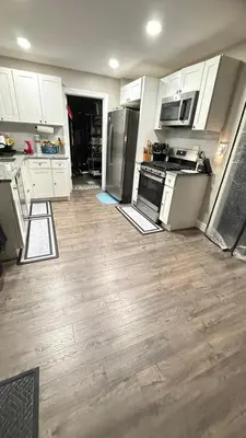 a kitchen with stainless steel appliances and wooden floors at Rooms available in a single Family home shared with Host in Willingboro