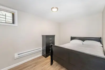 a bedroom with a bed and a dresser and a window at Cozy Basement 2 Bed in Passaic in Passaic