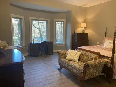 a bedroom with a bed and a couch with a chair at RiverFront Villa- Sleeps 11 in Lancaster