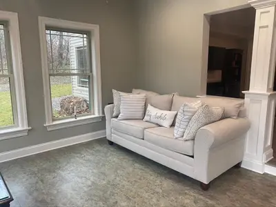 a couch in a living room with two windows at RiverFront Villa- Sleeps 11 in Lancaster