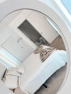 a reflection of a bed in a round mirror at Cozy Pocono Escape in Tobyhanna