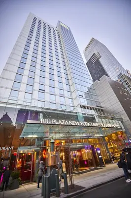 a tall building with people walking in front of it at Riu Plaza New York Times Square in New York