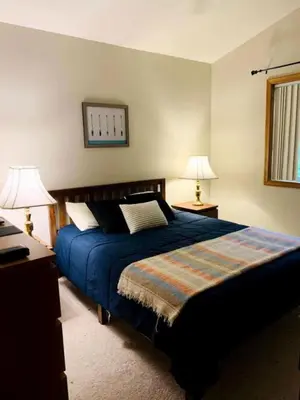 a bedroom with a blue bed and two lamps at Lake Cabin with Hot-Tub and Deck in Pennsylvania in Lake Ariel