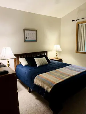 a bedroom with a blue bed and two lamps at Lake Cabin with Hot-Tub and Deck in Pennsylvania in Lake Ariel
