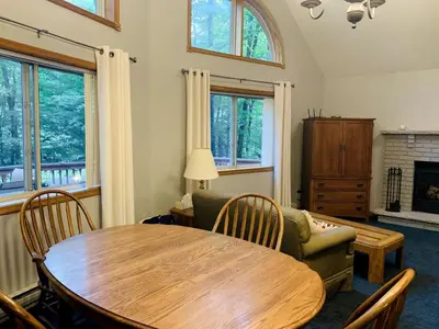 a living room with a wooden table and a couch at Lake Cabin with Hot-Tub and Deck in Pennsylvania in Lake Ariel