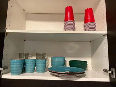 a shelf with blue and red cups and plates at New Jersey Apt 1 bd in Edison