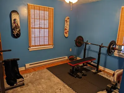 a blue room with a gym with a bench and weights at The Zen Den in Hellertown