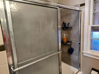a shower with a glass door in a bathroom at The Zen Den in Hellertown
