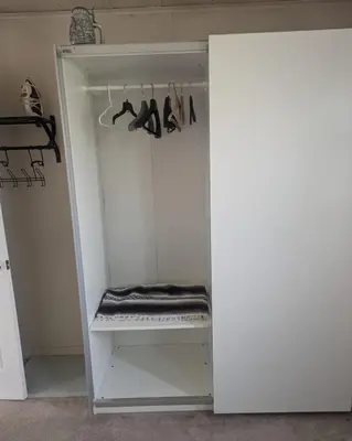 a closet with a white cabinet with shoes in it at The Zen Den in Hellertown