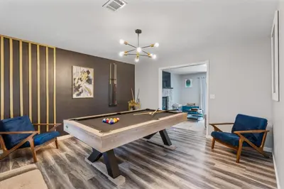 a living room with a pool table and two chairs at Emerald Lakes Poconos Retreat Game Room, Firepit & Sleeps 10 in Long Pond