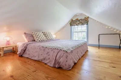 a bedroom with a bed and a window with lights at Alice in Wonderland Pocono Home in Honesdale