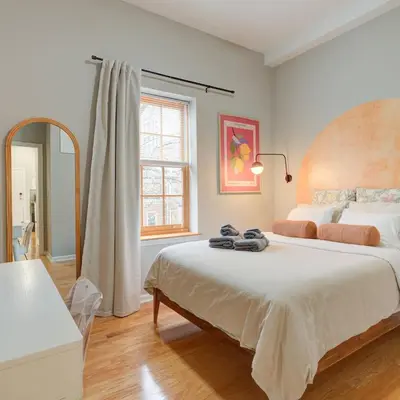 a bedroom with a large bed and a mirror at Cozy 1BD With Balcony in Philadelphia