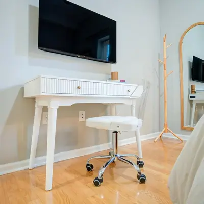 a white desk with a television on a wall at Cozy 1BD With Balcony in Philadelphia