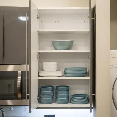 a kitchen cabinet with plates and a microwave at Cozy 1BD With Balcony in Philadelphia