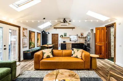 a living room with a couch and a kitchen at Stunning Catskills Cabin in Margaretville