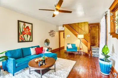 a living room with a blue couch and a table at 2 Mi to Dtwn Harrisburg Escape with Furnished Deck! in Harrisburg